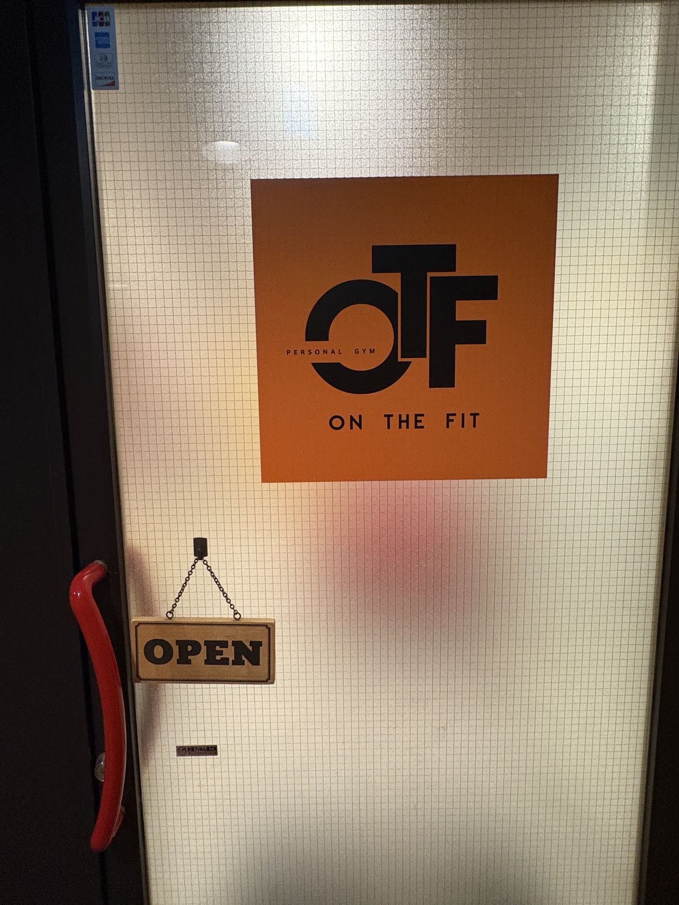 ONTHEFIT吉祥寺の入口。すりガラスのドアにOTFのロゴ