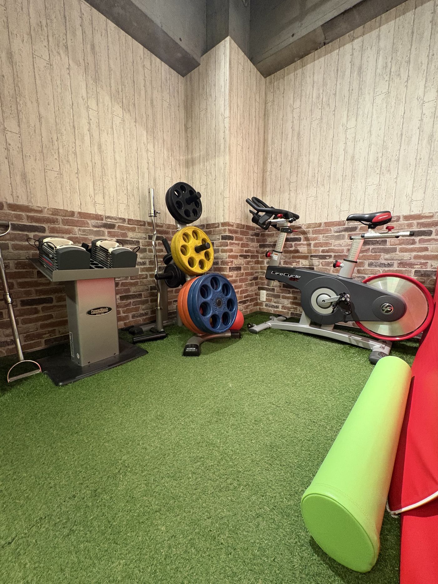 ONTHEFIT吉祥寺の個室。人工芝の床とダンベル、バイク